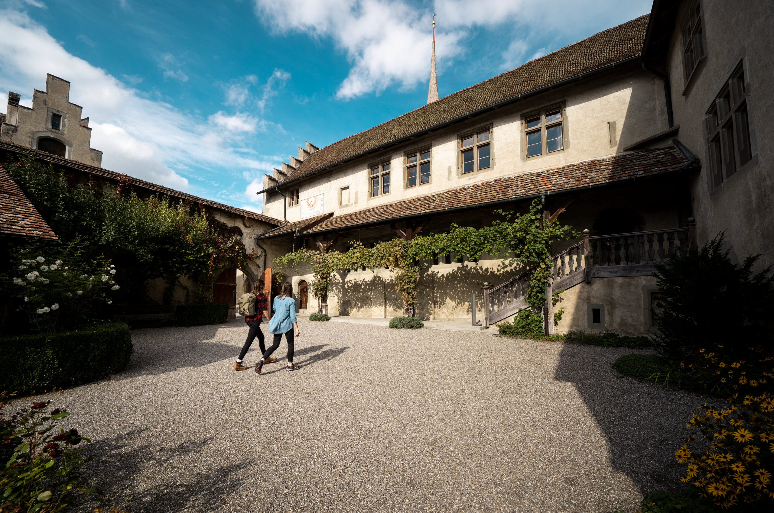Zwei Frauen laufen durch den Innenhof im Kloster St. Georgen.
